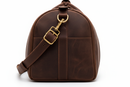 Side view close-up showing leather grain, stitching and brass hardware detail