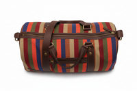 Top view close-up of zipper, hardware and leather handles on striped canvas duffel bag